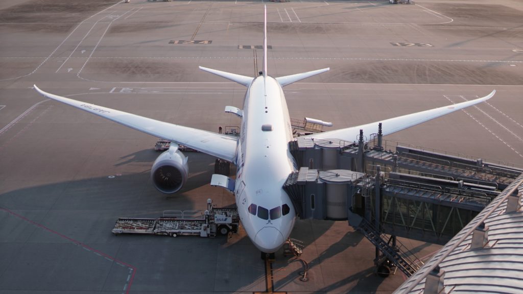 The overhead view of a plane with walkways connected to a terminal.