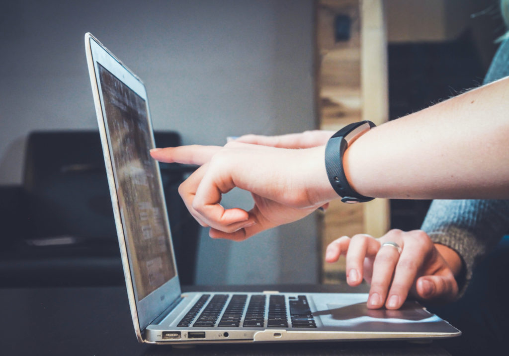 A supply chain professional points at a laptop.